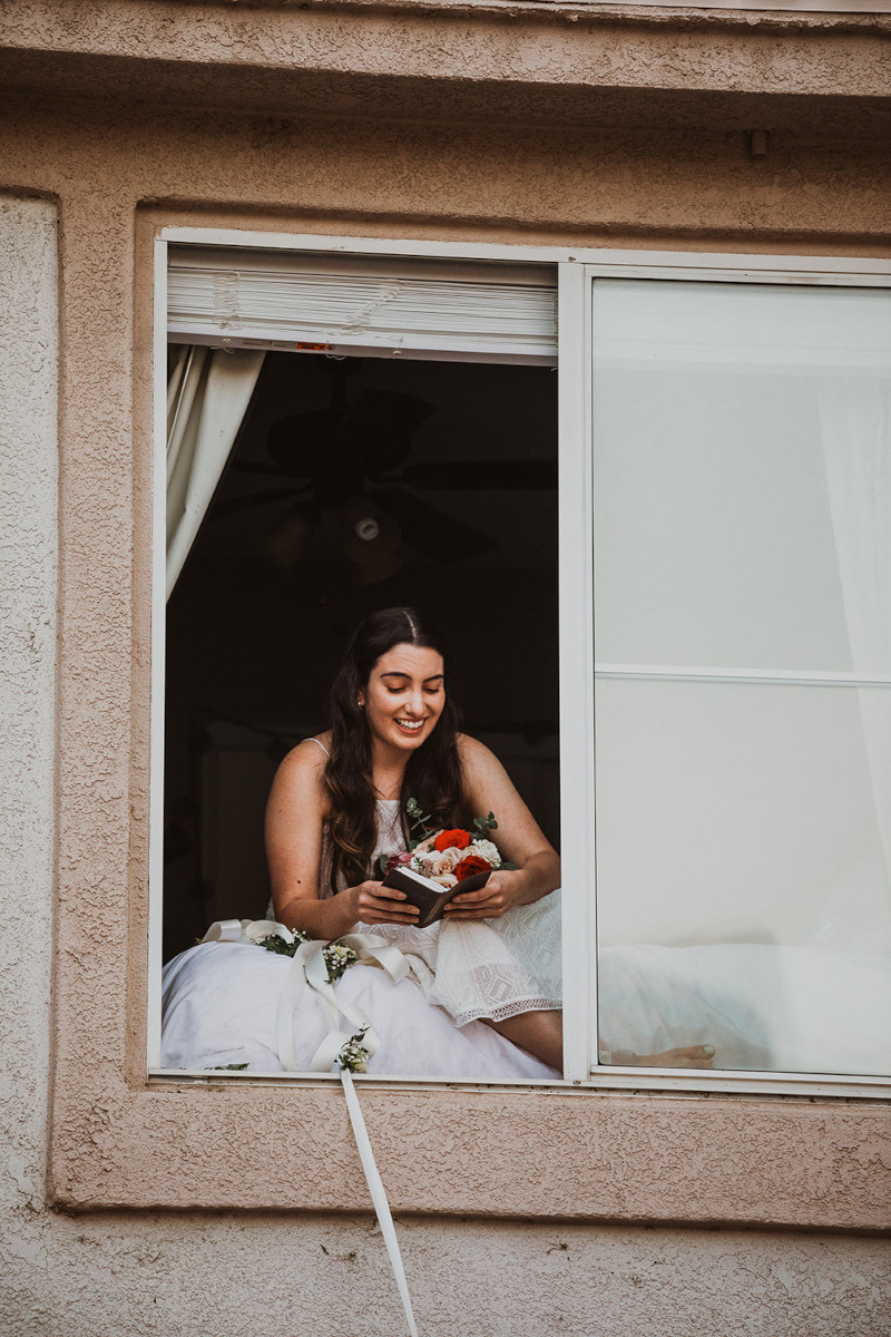 Η νύφη διαβάζει τους όρκους της από το παράθυρο του σπιτιού 